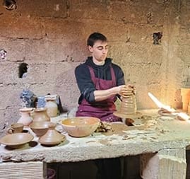 a man is making a pottery in a pottery workshop