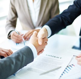 a group of people shaking hands over a table
