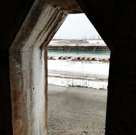 a window with a view of a train passing by. Waterbody through a frame