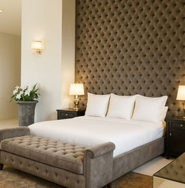 Tufted bed and bench with dark wall paneling, custom-designed by Solo Home Decor for a luxe bedroom.