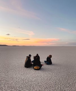Photo de groupe lors d'un coucher de soleil dans le Salar de Uyuni en Bolivie.