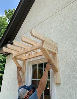 a man is holding a wooden structure in his hands