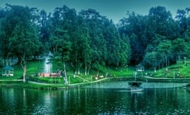 a lake with a boat in the water surrounded by trees