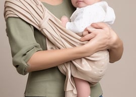 person holding baby's toe with yellow petaled flower in between