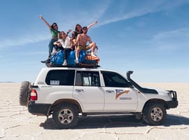 Photo de groupe sur le 4x4 lors du tour dans le Salar de Uyuni en Bolivie.