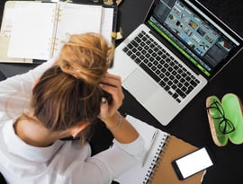 Vista cenital de mujer joven con una laptop, estresada