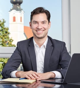 a man in a suit and tie smiling at the camera