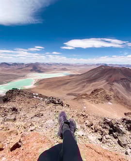 View from the summit of Licancabur volcano showing my legs, another volcano, and Laguna Verde.