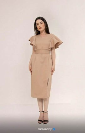 a woman in a beige dress with a brown dress