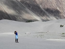 a woman in a blue dress is standing in the soil