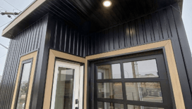 Modern prefab modular tiny home with black metal exterior