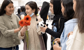 Nila Ibrahimi, second from left, is greeted by her old Marefat High School classmates at Saskatoon I