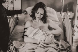 Mama cradling her newborn baby in a hospital bed in Grand Rapids, MN.