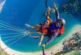 a man and woman parasailing over a body of water
