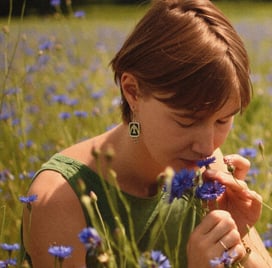 a woman in a yellow dress is holding a flower