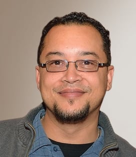 a man with glasses and a jacket on