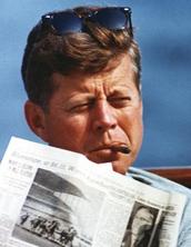 a man in sunglasses and sunglasses is reading a newspaper