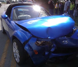 a blue car with a damaged front bumper getting fixed at fix collision center