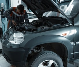 a man working on a car in a garage at fix collision center