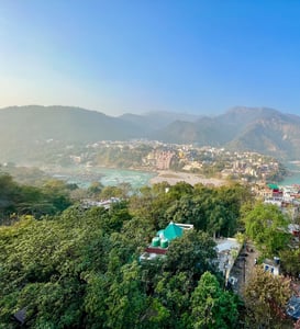 Scenic rooftop view overlooking the Himalayas and the Ganges River in Rishikesh, India, during a yoga retreat.