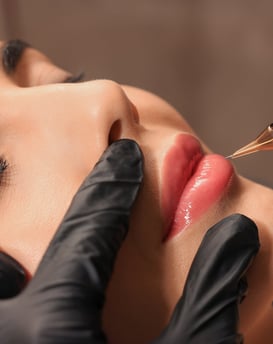 Eine Frau, die ihre Lippen von einer professionellen Kosmetikerin mit Permanent Make-up 