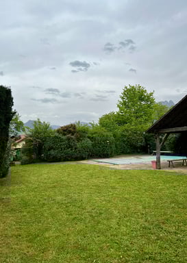 Entretien de jardin : pelouse tondue et haies taillées près d’une piscine