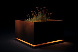 a planter with flowers in a black box