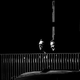 Two men, in shadow but with their faces lit by the sun at Exchange Plaza, Lothian Road, Edinburgh