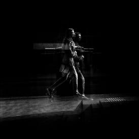 Two people walking, distorted through glass. The Usher Hall, Edinburgh