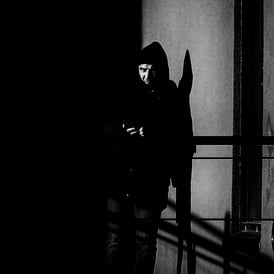 A man, in shadow, looks off to the distance at Lochrin Basin, Edinburgh