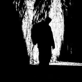 A man, in silhouette, walks along King's Stables Road, Edinburgh