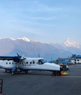 Plane on the runway at Lukla Airport, surrounded by the Himalayan mountains, Nepal.