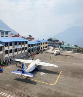 Airplane on the runway at Lukla airport preparing for takeoff.