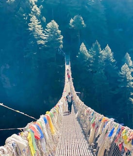 Suspension bridge along the Everest Valley trek, surrounded by Himalayan peaks.