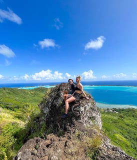 Manon et Laurent admirant la vue spectaculaire sur le lagon bleu de Bora Bora depuis un sommet.