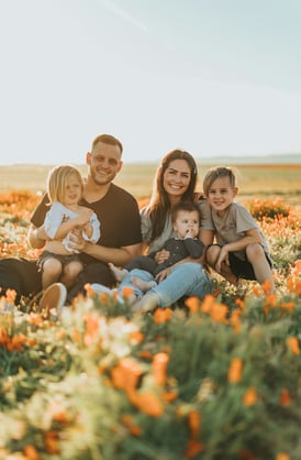 happy man and his family in a field of flowers