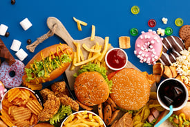 mesa azul com sanduiches, batatas fritas e outras frituras espalhadas