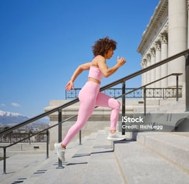 a woman running up stairs in a city