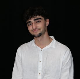 a man in a white shirt and tie dye on a black background