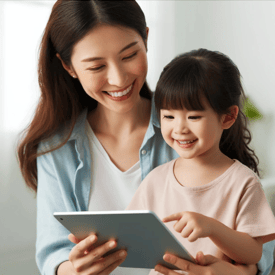 a woman therapist with a young child holding a tablet computer and smiling