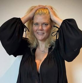 a woman in a black dress and a white wall
