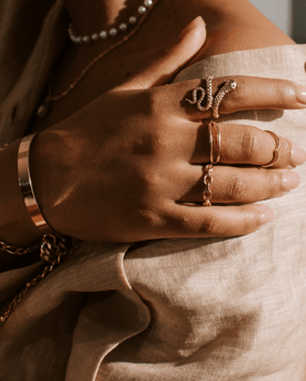 a woman's hands holding a cross on a dress shirt