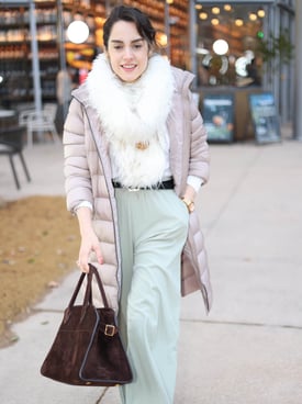 a woman in a white coat and a brown bag