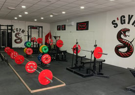 a gym room with a bunch of different colored gym equipment