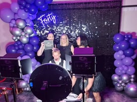 Group in the pimped out photo booth with black shimmer wall and balloon garland, Logan.