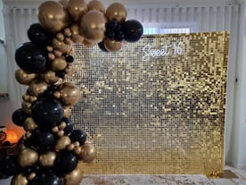 Gold shimmer wall with matching gold and black garland for sweet 16 in Brisbane.