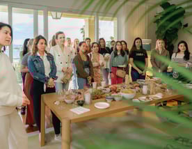 Fertility community event with women gathered around a shared table, connecting over food and shared