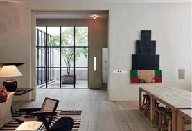 Interruptores de diseño integrados en salón moderno con luz natural y acabados minimalistas