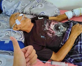 a man in a hospital bed with an ngt tube attached