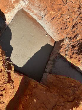 a person standing on a rock face with a shadow on the ground